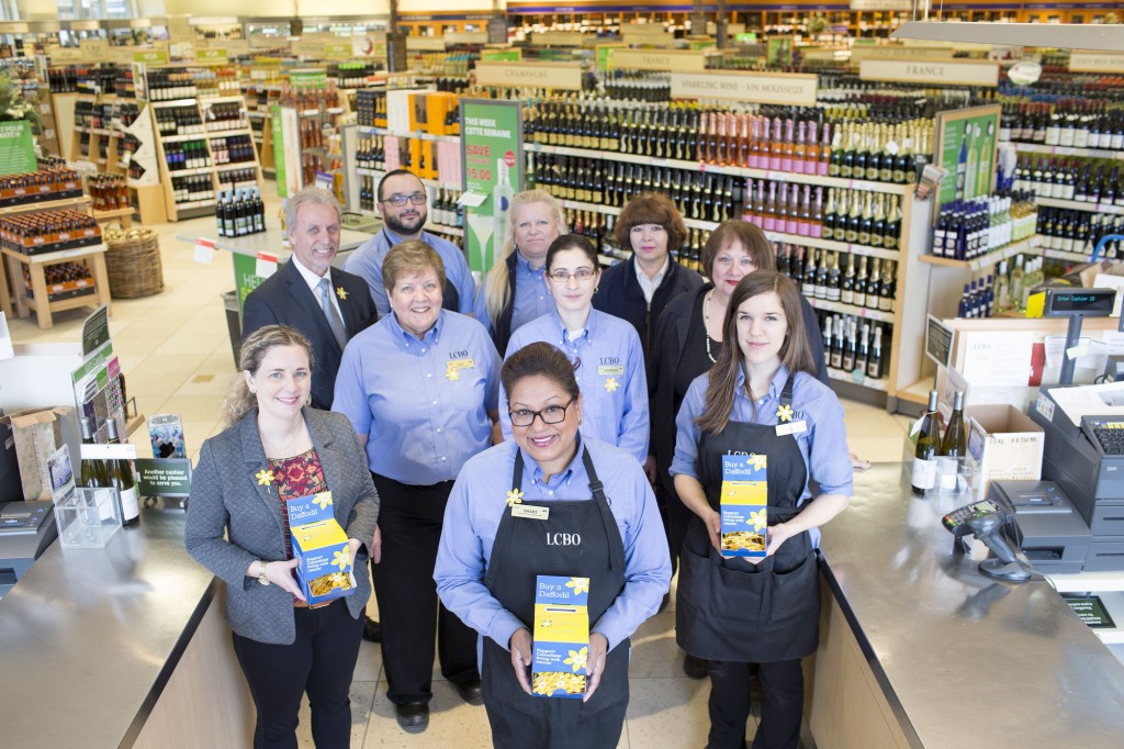The team at the Dupont and Spadina LCBO store in Toronto join Susan Drodge (far left) of the Canadian Cancer Society to kick off Daffodil Month pin sales efforts at the LCBO'-s more than 650 stores across Ontario. (CNW Group/Canadian Cancer Society (Ontario Division))